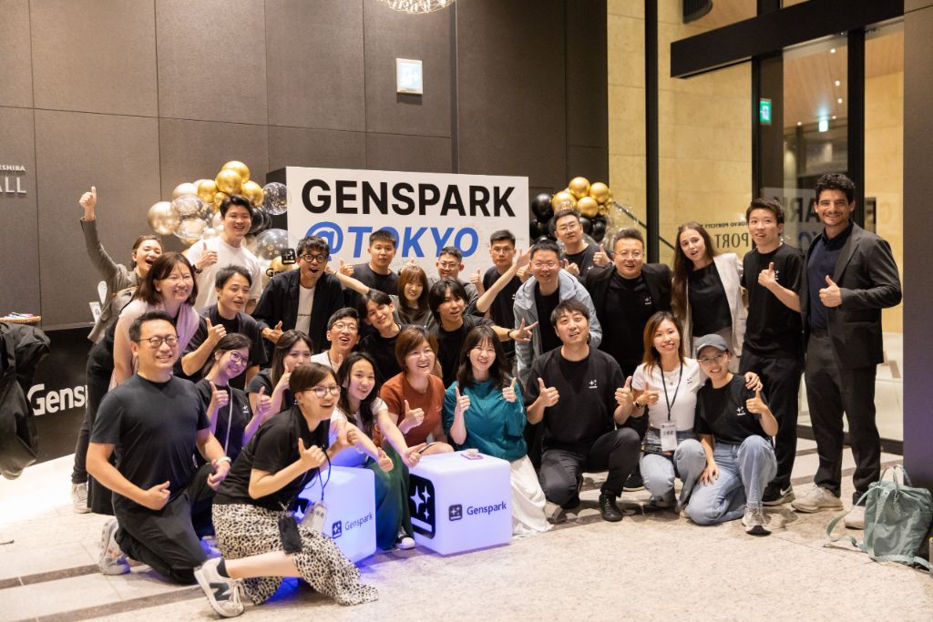 Het Genspark-team uit Tokyo rond een bord met GENSPARK @ TOKYO en gouden ballonnen